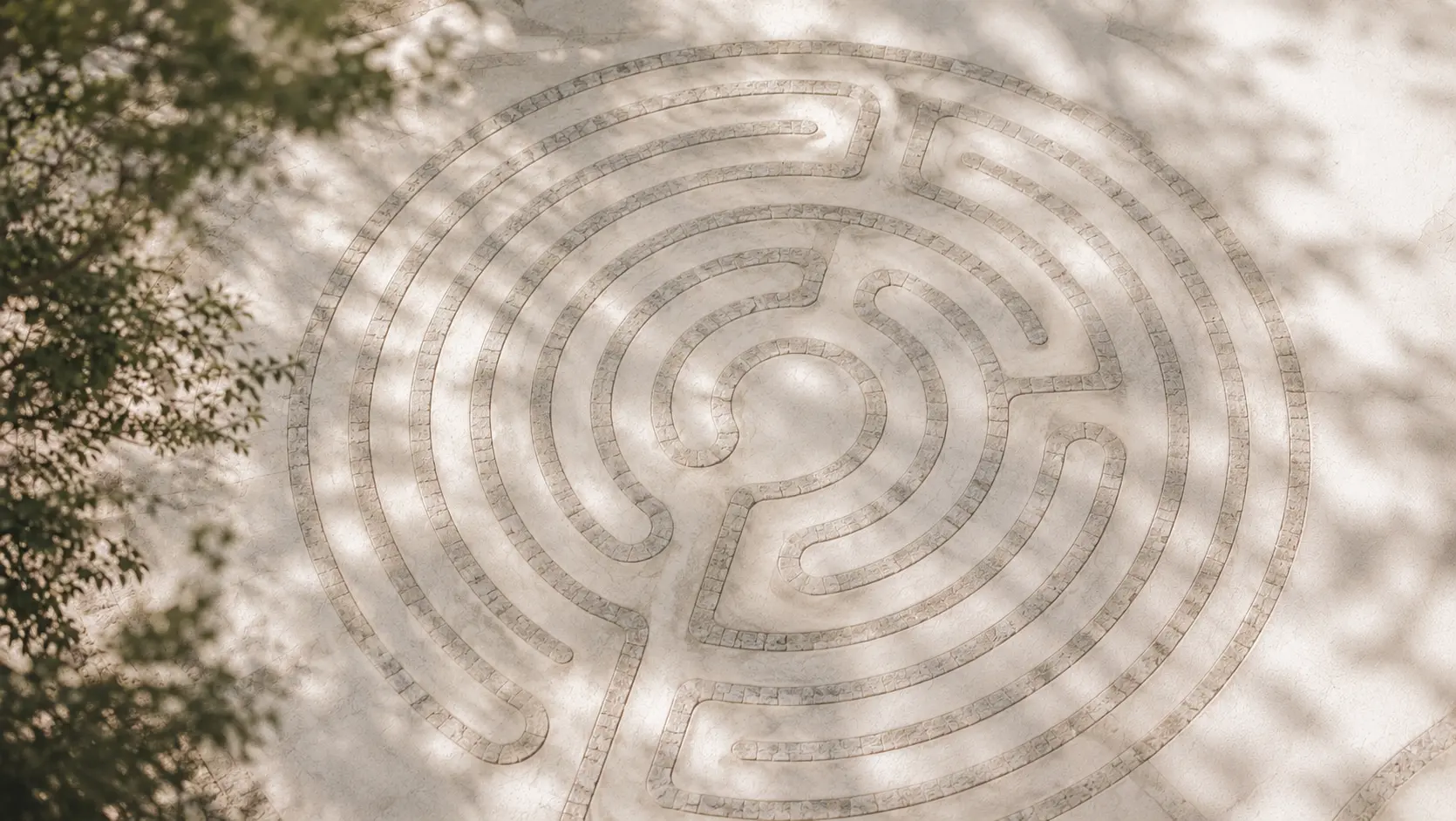 Blick von oben auf ein in Stein gelegtes Labyrinth im warmen Licht